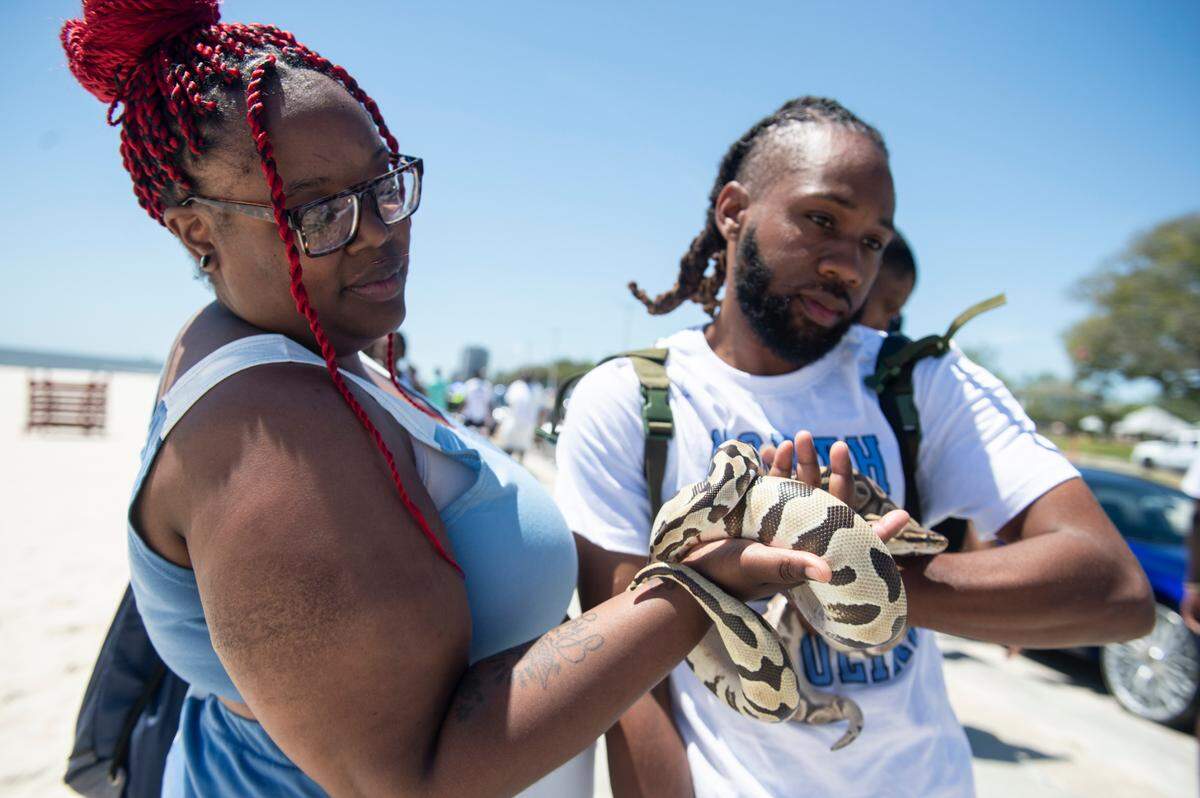 Spring breakers show off snakes during Black Spring Break in Biloxi on Saturday, April 13, 2024.