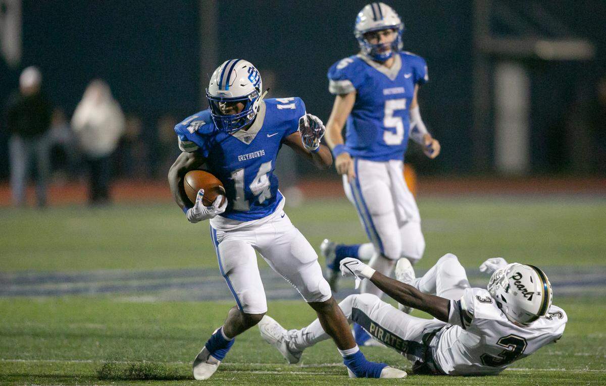 Ocean Springs’ John Paul Coulter, left, avoids getting tackled during a playoff game at Greyhound Stadium in Ocean Springs on Friday, Nov. 12, 2021.