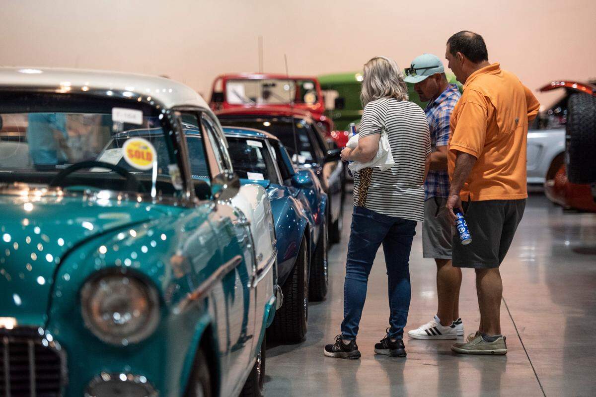 Visitors look at cars up for auction during the Vicari car auction at the Mississippi Coast Coliseum and Convention Center on Thursday, Oct. 7, 2021.