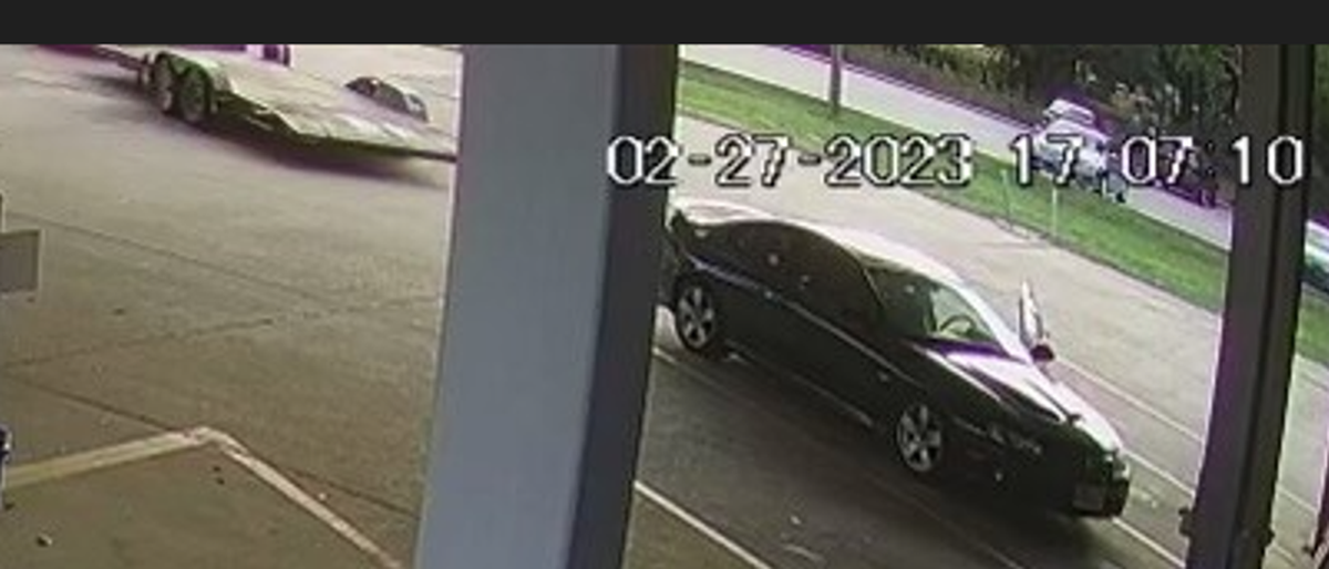 Surveillance footage shows the silver truck backed the flatbed trailer to the stolen GTO before two suspects loaded the vehicle.