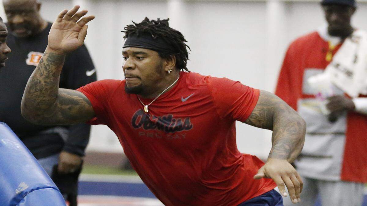 Defensive tackle Robert Nkemdiche, right, fights off a block by a scout during a position drill at Mississippi's NFL football Pro Day, Monday, March 28, 2016, in Oxford, Miss. The event is to showcase players for the upcoming NFL football draft. (AP Photo/Rogelio V. Solis)