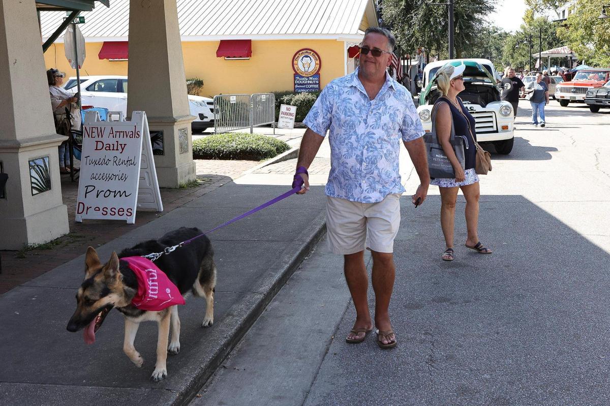 A man and his dog enjoy a sunny day and beautiful old cars during the Ocean Springs Cruisin’ the Coast Block Party, October 8, 2021.