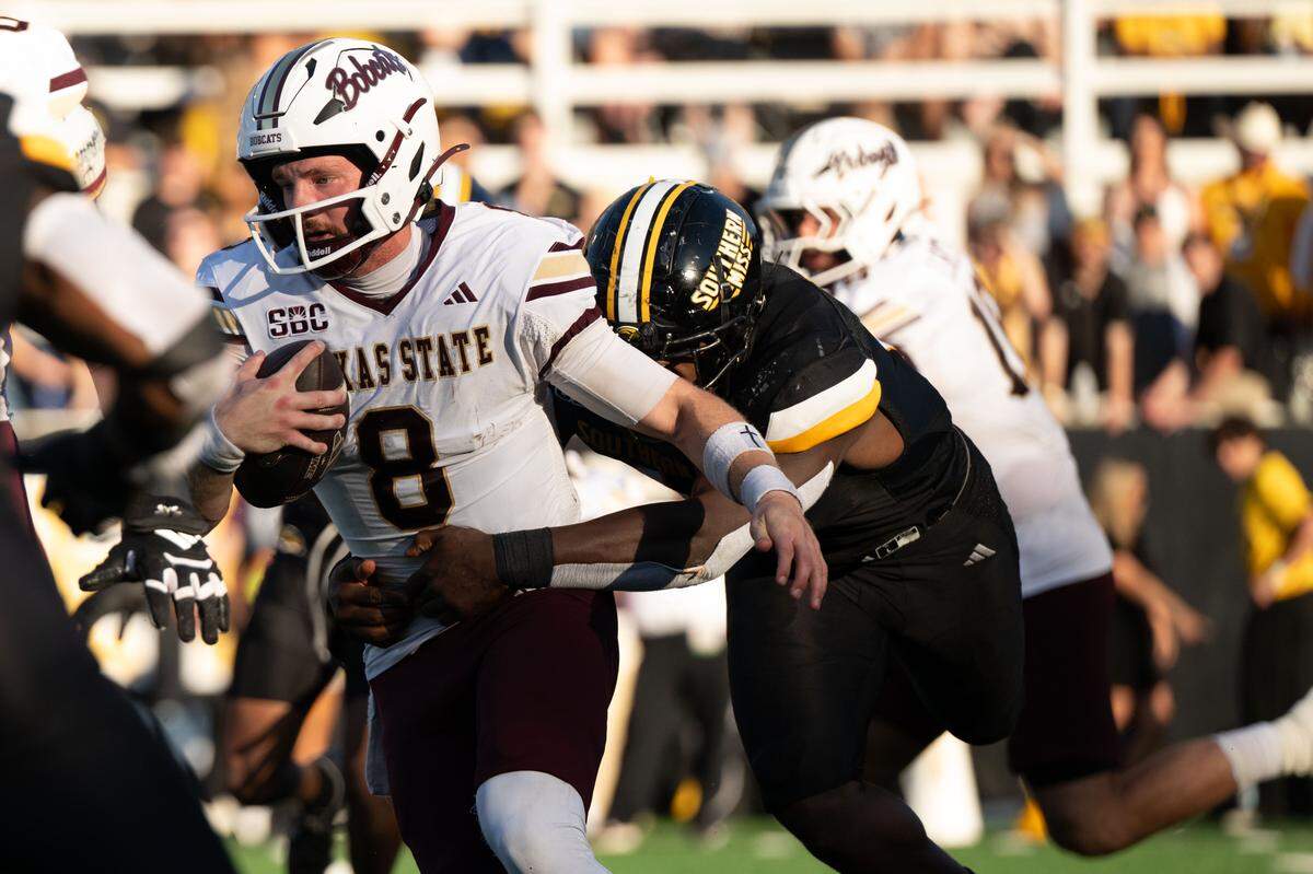 Southern Mississippi defensive lineman J'Mond Tapp (14) tackles Texas State quarterback Brad Jackson (8).