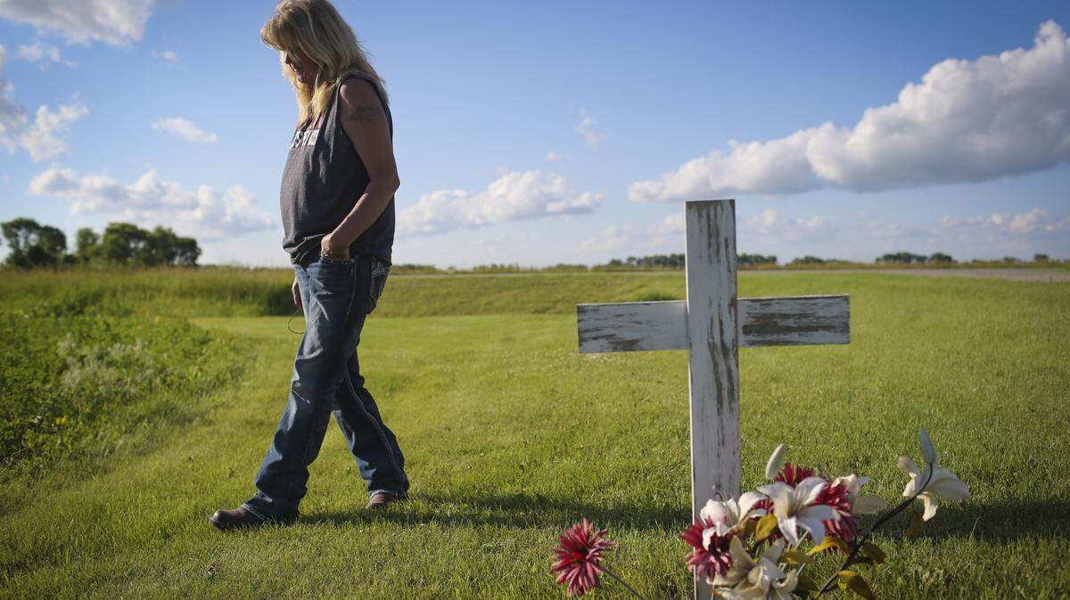 Gayle Lund walks by a cross she put in the spot of her driveway where her 24-year-old son Jake Fuglie died in a tractor rollover in 2010 on June 22, 2015 in Ulen, Minn. Fugally was driving his grandfather's old tractor to plow snow and it tipped on the small incline of the grass by the driveway. (Renee Jones Schneider/Minneapolis Star Tribune/TNS)