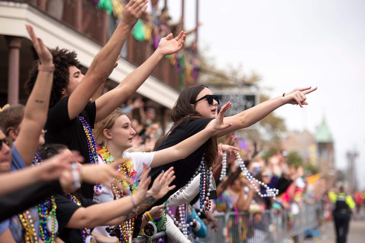 Parade watchers catch beads and other throws during the Gulf Coast Carnival Association Mardi Gras parade in Biloxi on Tuesday, March 4, 2025.