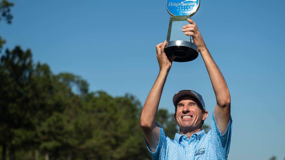 Steve Alker, winner of the Rapiscan Systems Classic, hoists the trophy in the air following his win at Grand Bear Golf Course in Saucier on Sunday, April 3, 2022.