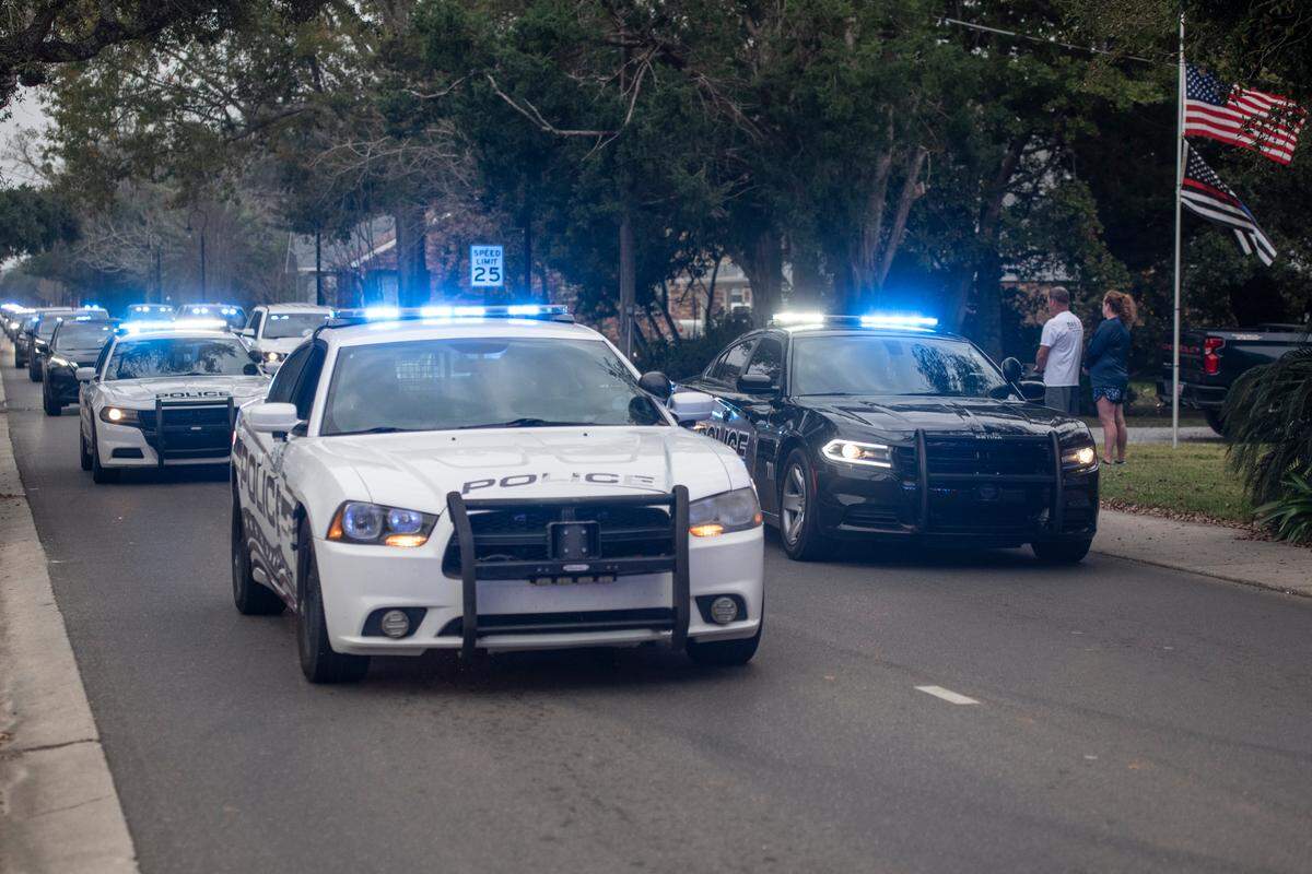 A procession of law enforcement officers drives down Main Street in Bay St. Louis escorting the body of Sgt. Steven Robin as it is taken to Edmond Fahey funeral home on Wednesday, Dec. 14, 2022. Robin was killed along with another officer while on duty.