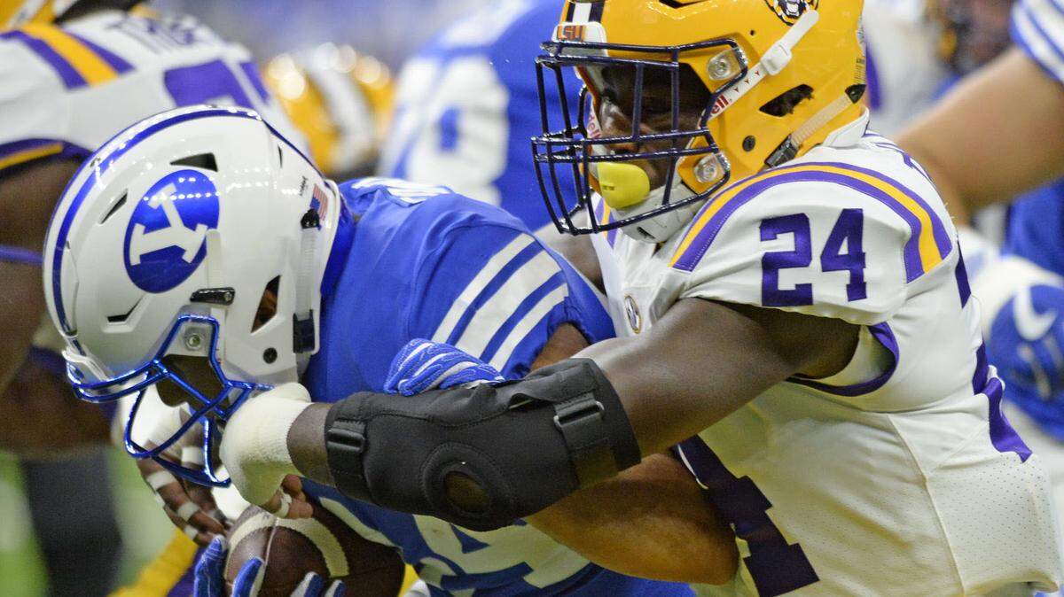 LSU linebacker Tyler Taylor, 24, tackles BYU defensive lineman Langi Tuifua, 49, during his first college game last season. Taylor has been suspended from the football team, LSU announced Wednesday, Aug., 8, 2018.
