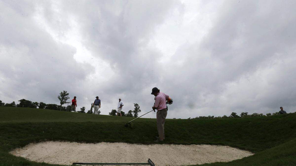 Storm clouds loom as grounds crew groom the 18th hole before the start of the third round of the PGA Zurich Classic golf tournament at TPC Louisiana in Avondale, La., Saturday, April 30, 2016. (AP Photo/Gerald Herbert)