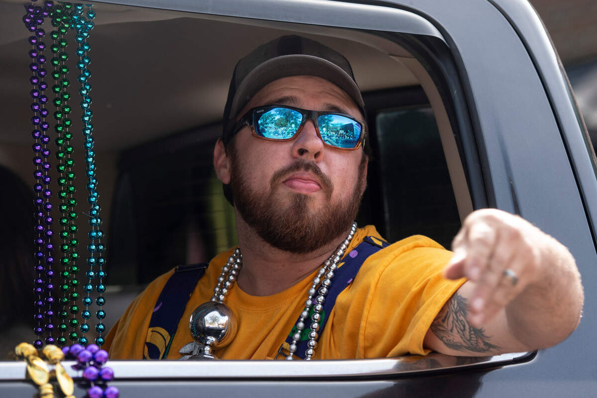 A float rider tosses throws during the Ocean Springs Elks Club Mardi Gras Parade in Ocean Springs on Saturday, Feb. 15, 2025.