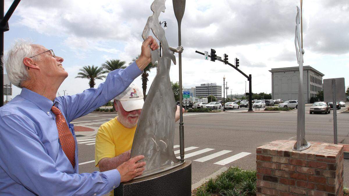 John Harral of the Mississippi Sound Maritime Historical Foundation helps Jim Collins of Signal Mountain, Tenn., remove the smaller version of his sculpture ‘Sailor’ after installing a larger, permanent version, right, on 13th Street in Gulfport in June 2016.