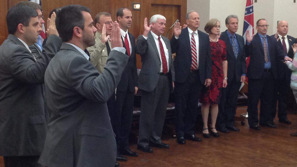 KAREN NELSON/SUN HERALDCounty officials sworn into office Friday range from constables to the tax assessor. Part of the group are Constable Kerry Fountain, foreground; county Supervisor Troy Ross, left; Sheriff Mike Ezell, face showing near Fountain's hand. To Ezell's right are Tax Assessor Nick Elmore, Supervisor Barry Cumbest, Supervisor Ken Taylor, election commissioners Tammy Vidrine and Michael Dickinson, Constable Ty Thompson and Supervisor Randy Bosarge.
