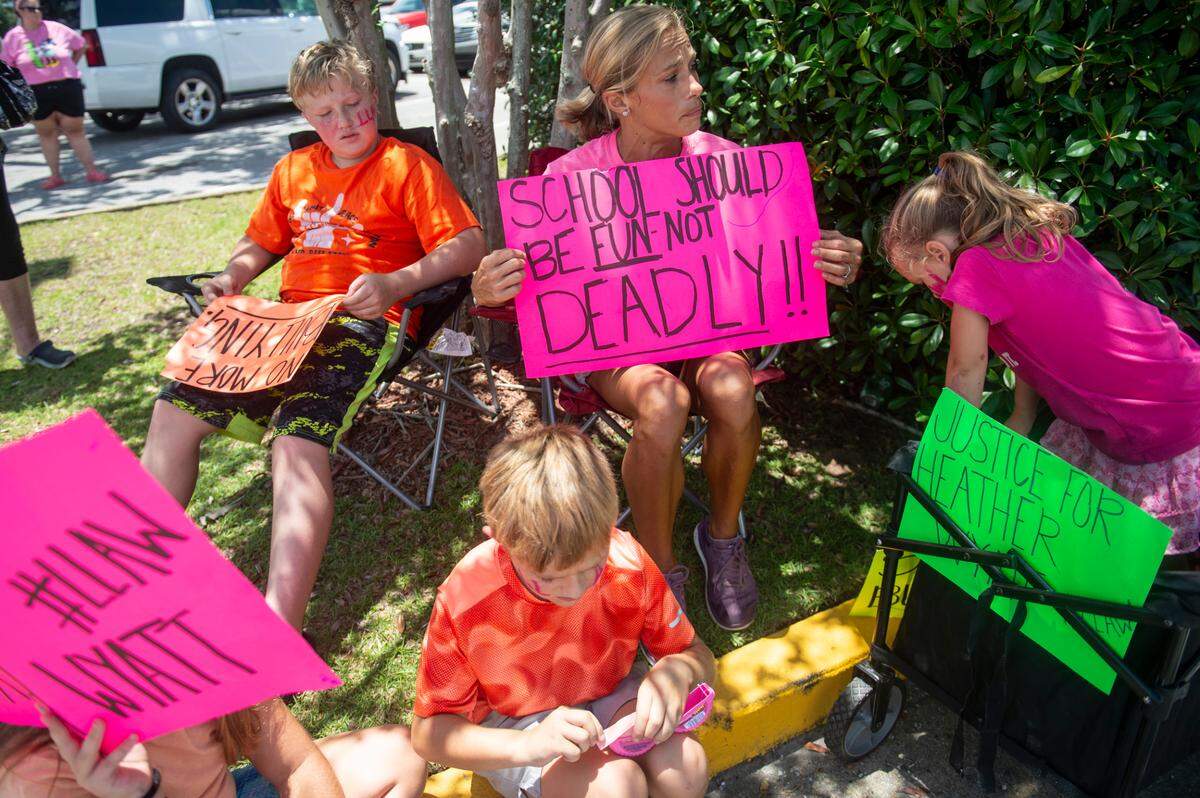 Jessica Stanley, center, and her four children sit outside the Jackson County Courthouse in Pascagoula on Thursday, July 18, 2024, as Heather Wyatt participates in a hearing over her social media in chancery court.