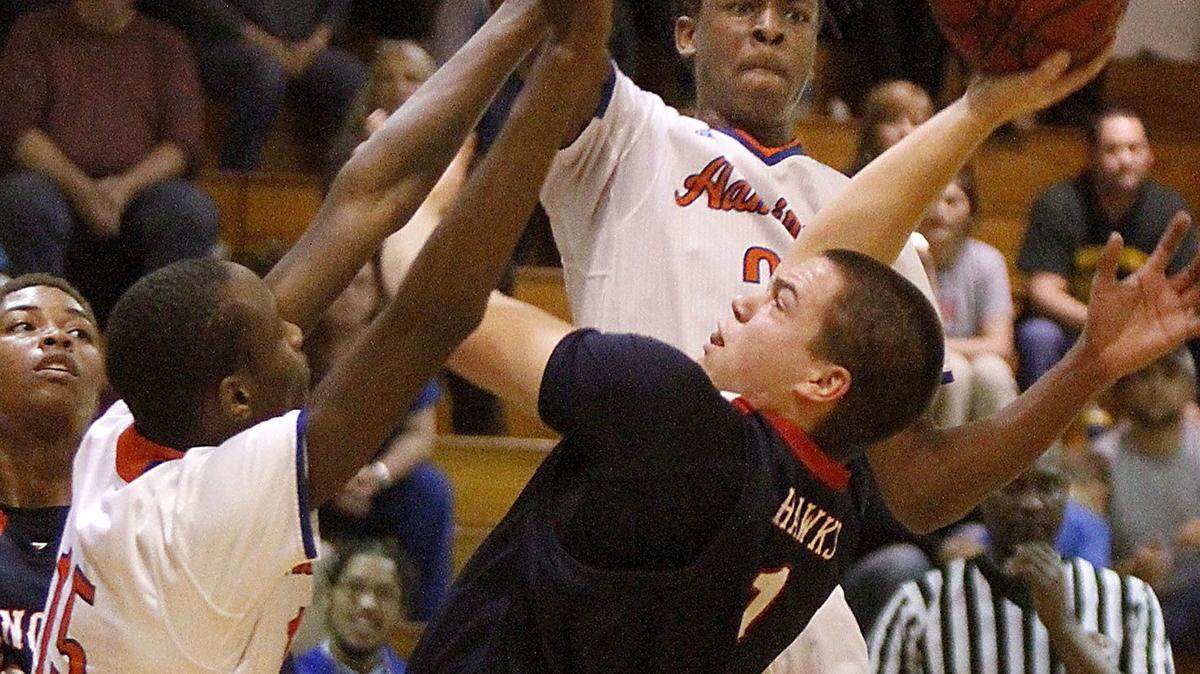 TIM ISBELL/SUN HERALD 
 Hancock's Tyler Butler has his shot blocked by Gulfport's Carl Terrell, Tuesday. Gulfport will face rival Biloxi in the 8-6A championship game on Friday.