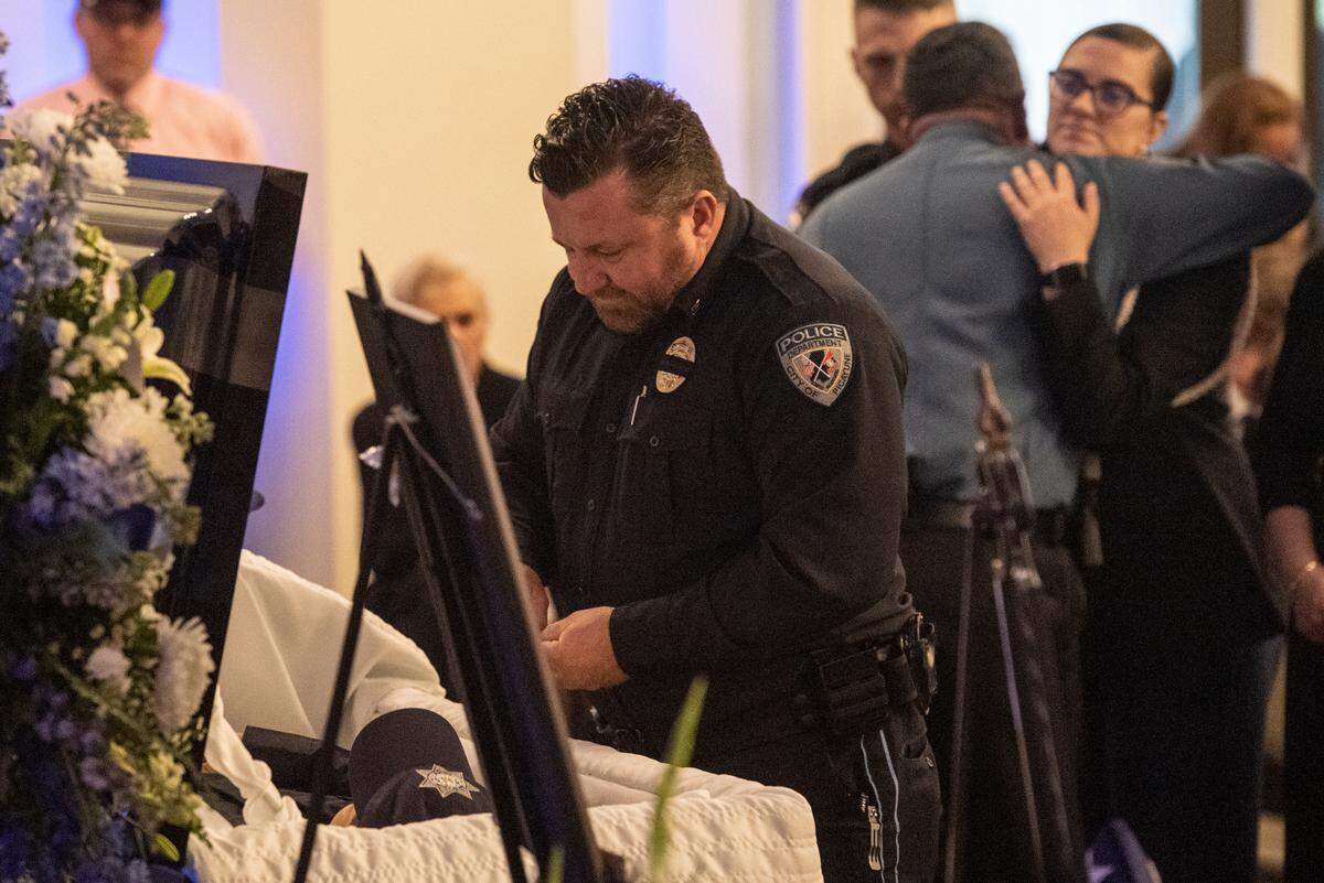 Ian Estorffe looks into the casket of his son Branden Estorffe during the funeral of Bay St. Louis police officers Sgt. Steven Robin and Branden Estorffe at the Bay St. Louis Community Center in Bay St. Louis on Wednesday, Dec. 21, 2022. Robin and Estorffe were killed responding to a call at a Motel 6 on Dec. 14.