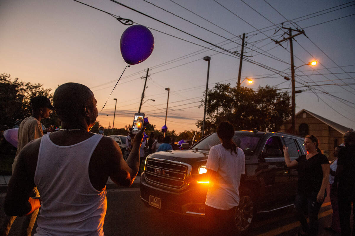 Family and friends of Inez Thomas watch as a car pulls up filled with balloons to be released in her honor in East Biloxi on Friday, Oct. 22, 2021.