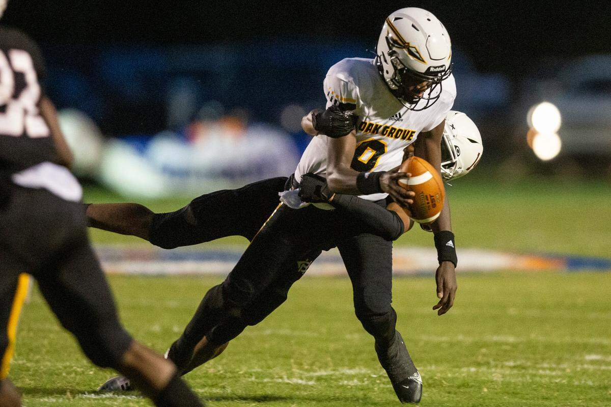 Oak Grove quarterback A.J. Maddox gets sacked by Harrison Central’s defense during a game against Harrison Central at Milner Stadium in Gulfport on Friday, Aug. 26, 2022.