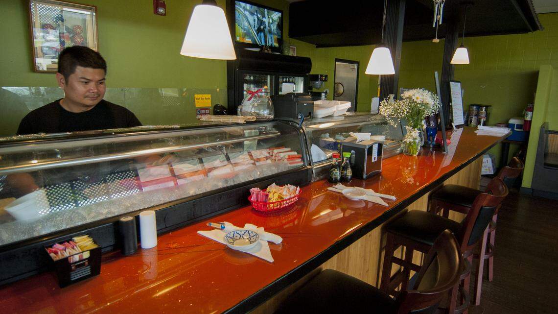 Soupha "Lee" Sayavong, the co-owner of Sushilicious and Thai in Waveland, prepares sushi from behind his refrigerated case in this June 2017 photo.