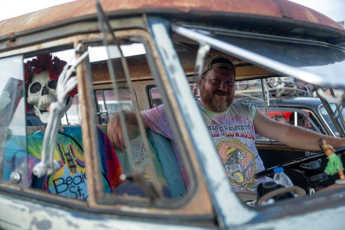 Paul Sims sits in his bus with his prop skeleton Bertha during the Long Beach Cruisin’ The Coast Parade.