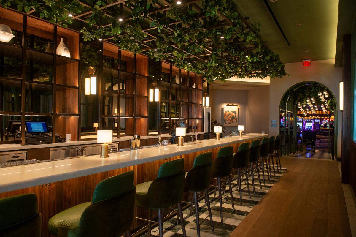 A trellis with greenery hangs over the bar at Coraline’s seafood restaurant at Beau Rivage Resort and Casino in Biloxi, giving it the feel of New Orleans.