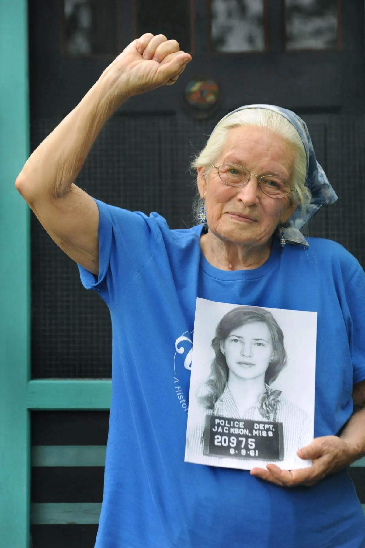 Joan Mulholland is seen holding a photo of her booking shot taken when she and other Freedom Riders were arrested in Mississippi in 1961.