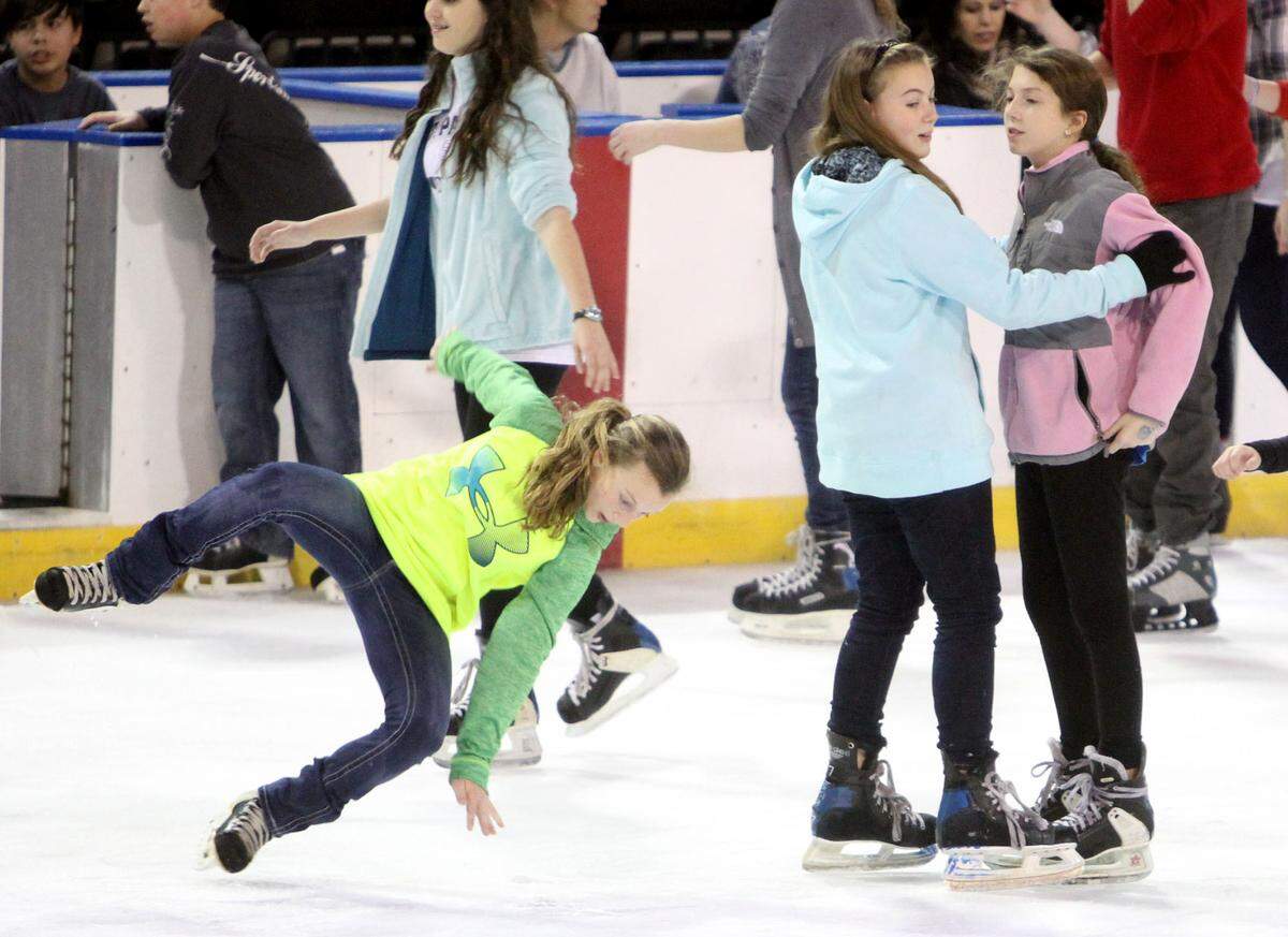 JOHN FITZHUGH/SUN HERALD Alyssa Richardson, 12, of Waveland falls as she ice skates with McKenzie Favre, 11, of Bay St. Louis and Payton Rayborn, 11, of Waveband at the Mississippi Coast Coliseum in Biloxi on Sunday Jan. 3, 2015.