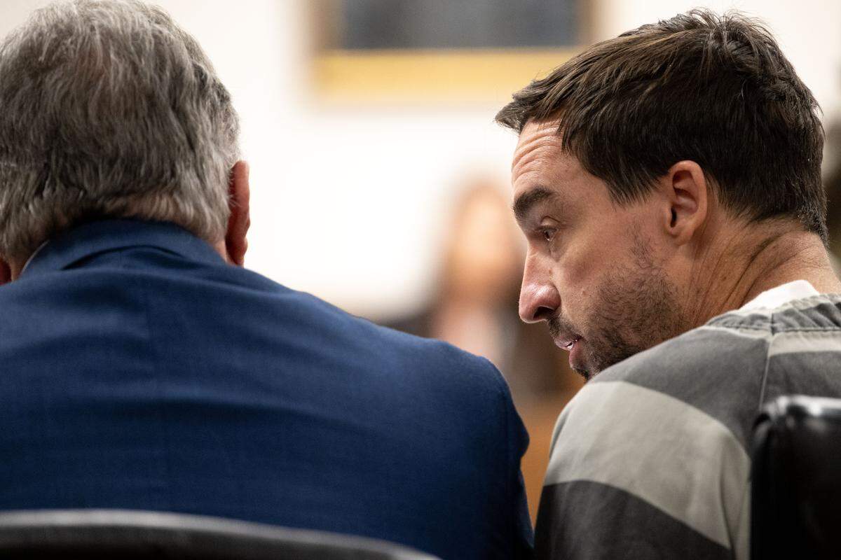 Alan Moran, right, speaks with his father Philip Moran, left, during a hearing Tuesday in Harrison County Circuit Court.