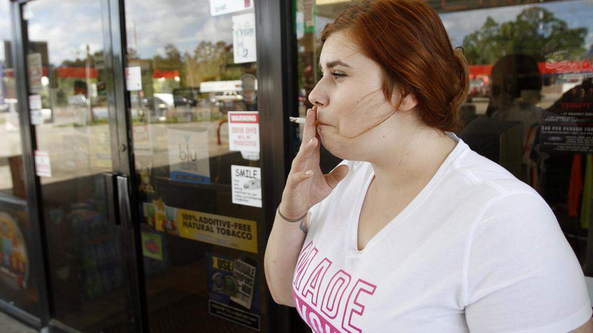 TIM ISBELL/SUN HERALD 
 Dakota Jackson smokes outside of the front door of Dolly's in Kiln, Tuesday, Apr. 26, 2016. Dolly's has gone smokeless.