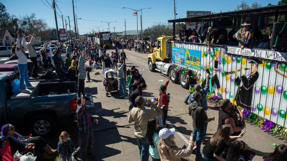 Crowds cheer for beads to be tossed in their direction during the Krewe of Nereids Mardi Gras parade on Highway 90 in Bay St. Louis on Sunday, Feb. 12, 2023.