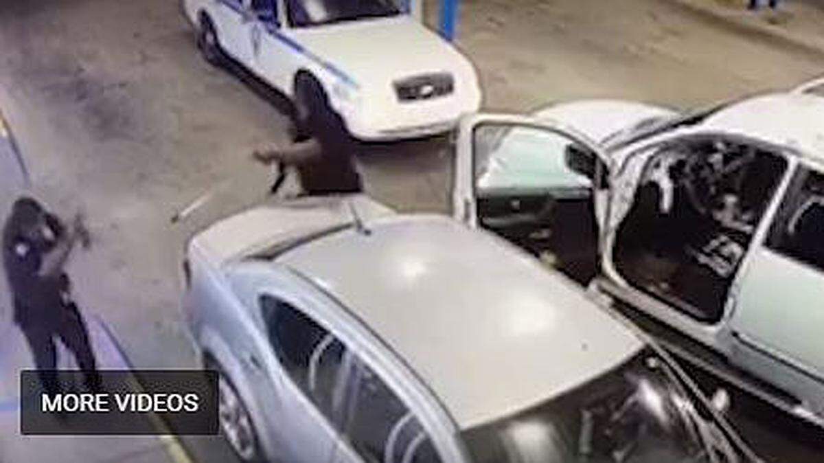 A frame from video surveillance shows a suspect identified as Chauncy Reed pointing a weapon at a Jackson police officer.
