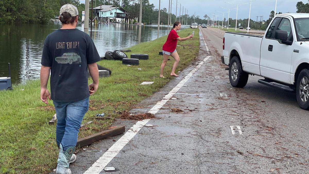 Jennifer Poillion confronts a looter on the shoulder of Mississippi 603 in Bay St. Louis, where he was picking up tires that had floated to a spot near the road. The same white pickup truck was spotted earlier Monday loading up tires and machinery from the business, Scrap Giant.