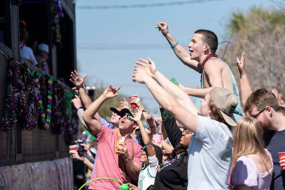 Parade attendees try to catch beads during the Jackson County Carnival Association Mardi Gras parade in Pascagoula on Saturday, March 1, 2025.