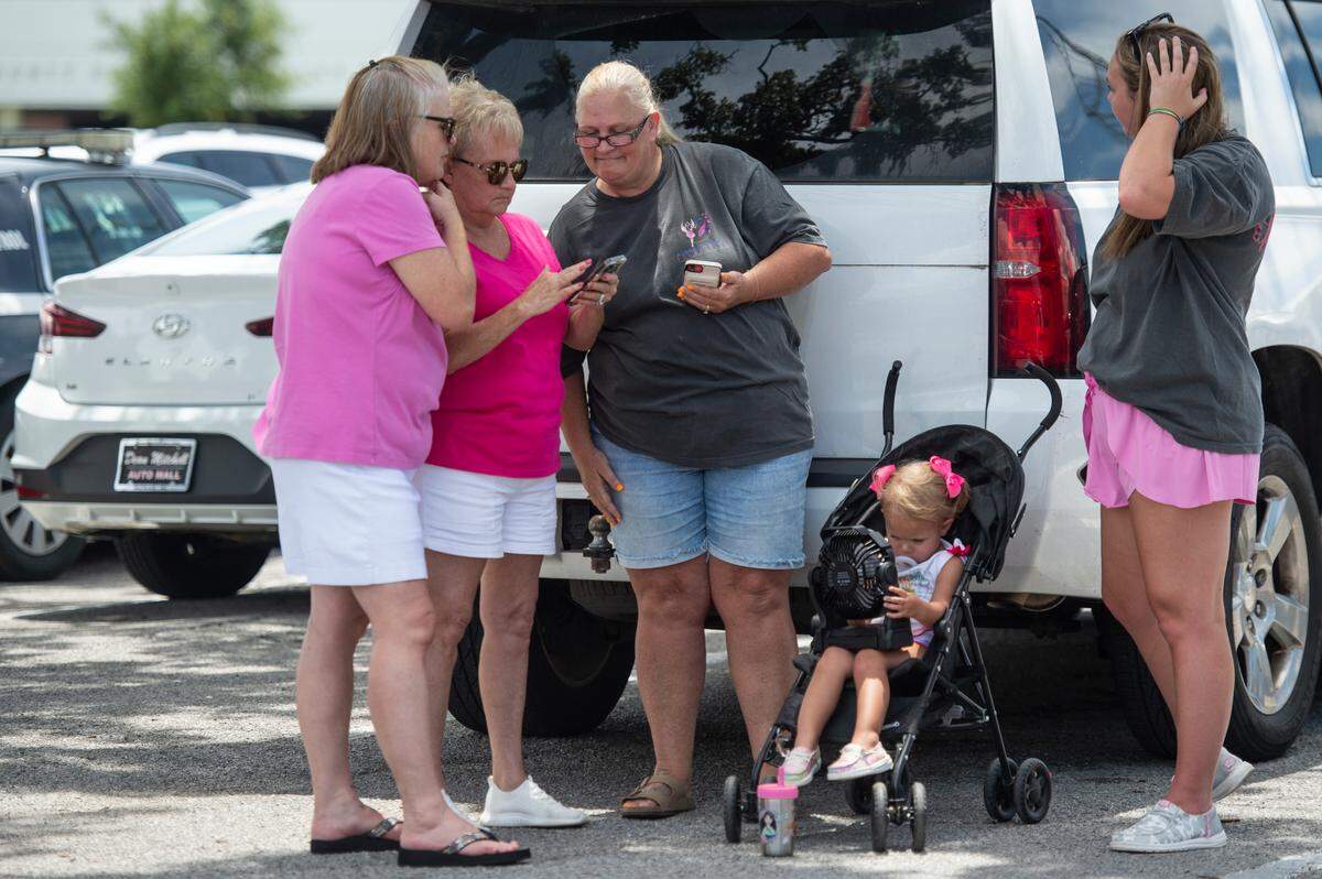 Protestors in support of Heather Wyatt and Aubreigh Wyatt try to keep cool in the shade as they wait outside the Jackson County Courts building on Thursday, July 18, 2024, as Heather Wyatt participates in a chancery court hearing inside the courthouse.