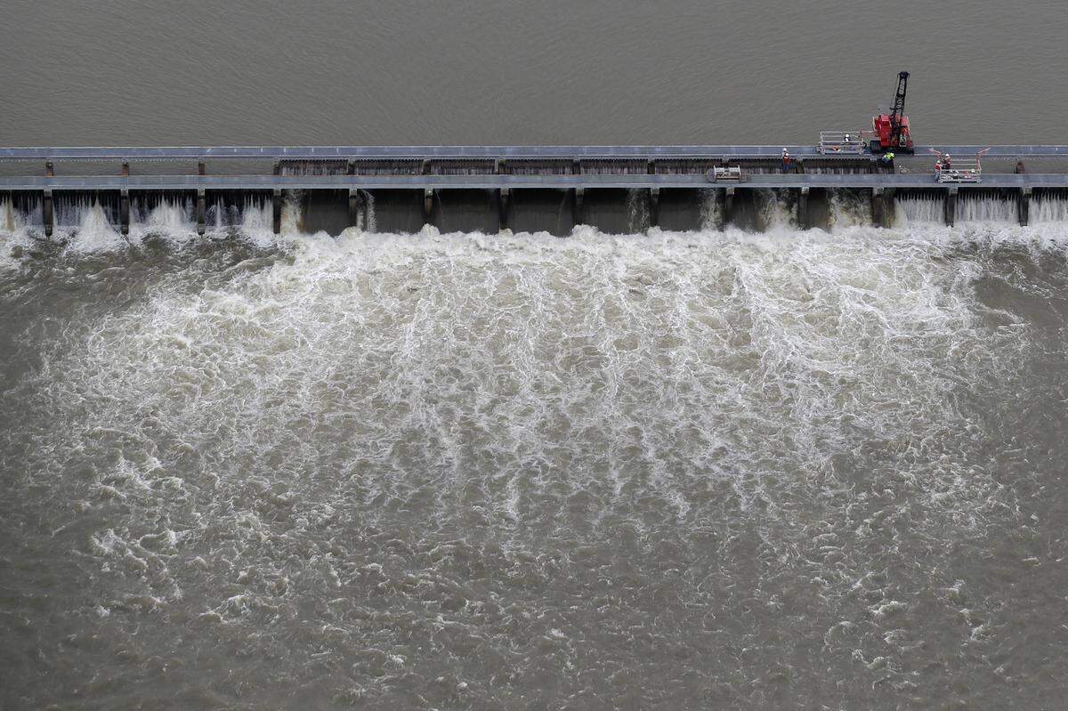 Workers in May open bays of the Bonnet Carré Spillway to divert rising water from the Mississippi River to Lake Pontchartrain, upriver from New Orleans, in Norco, Louisiana. This was the first time the spillway has opened twice in one year, with the earlier opening in February. From the lake, the river water flows into the Mississippi Sound.