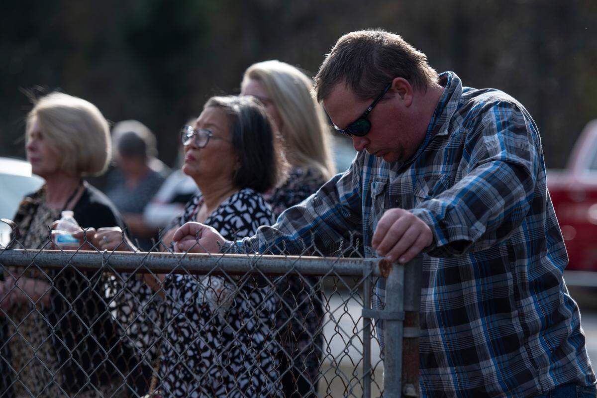 Attendees react to the final radio call during a graveside service for George County Sheriff’s Deputy Jeremy Malone at Tanners Cemetery in George County on Friday, Jan. 12, 2024.