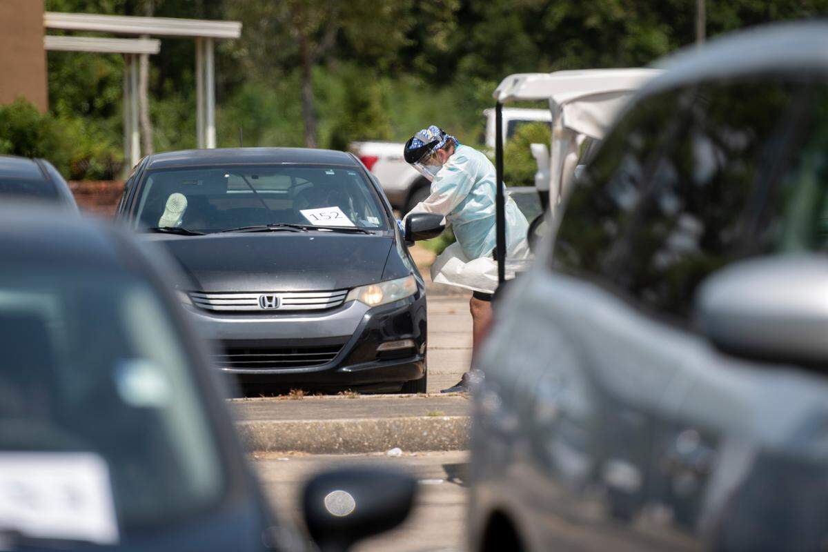 A nurse gives a patient their COVID-19 test results in the parking lot of Memorial Hospital’s COVID-19 testing site in Gulfport on Monday, Aug. 23, 2021.