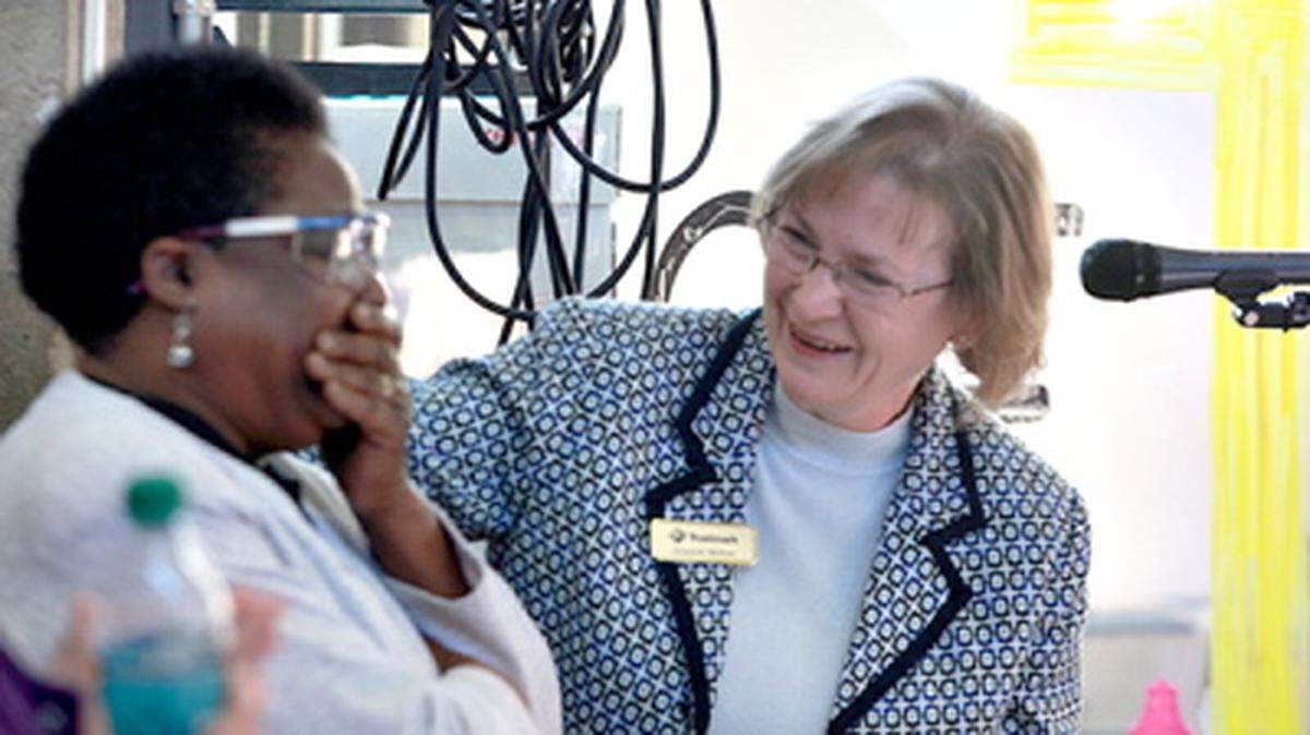 AUSTIN VINING/THE VICKSBURG POST 
 Lions Club sight chairperson Jeannie Melton, right, presents Donna Hall with checks to cover the $900 expense for her specialty glasses during a surprise assembly at St. Aloysius High School. The Lions Club raised the money in conjunction with St. Al's National Honor Society. Hall, has served as maintenance staff for 30 years at Vicksburg Catholic School, and she has been legally blind since 2012.