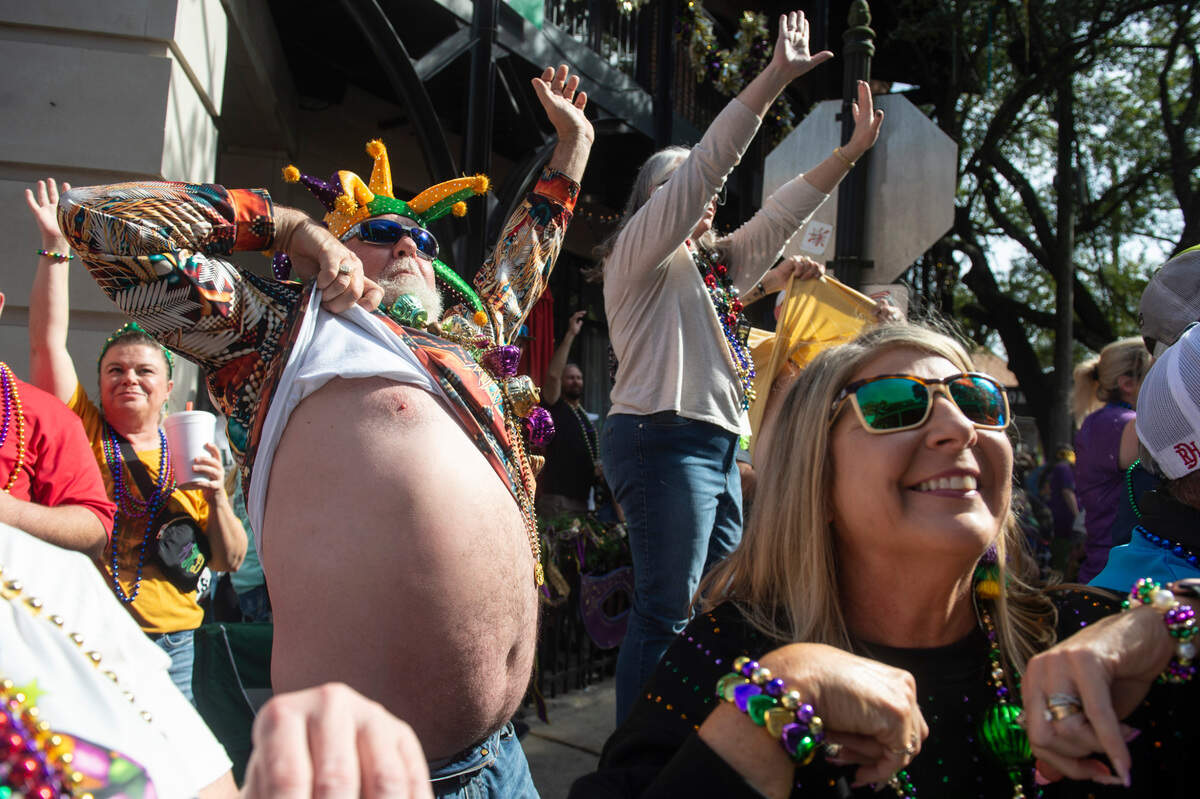 A man lifts his shirt as he cheers for throws during the Ocean Springs Elks Club Mardi Gras Parade in Ocean Springs on Saturday, Feb. 15, 2025.