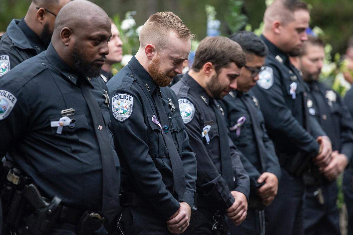 Bay St. Louis police officers react as Capt. Rachel Jewell calls in the last radio call at the gravesite of Bay St. Louis police officers Sgt. Steven Robin and Branden Estorffe at Gardens of Memory cemetery in Bay St. Louis on Wednesday, Dec. 21, 2022. Robin and Estorffe were killed responding to a call at a Motel 6 on Dec. 14.