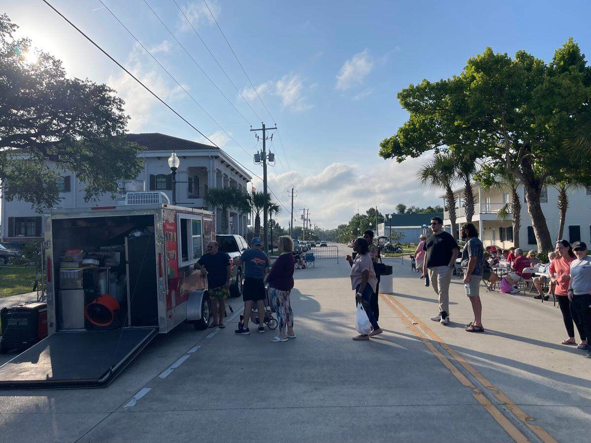 A line of people wait to try Jamaican food at Waveland’s Food Truck Friday event on Coleman Avenue.