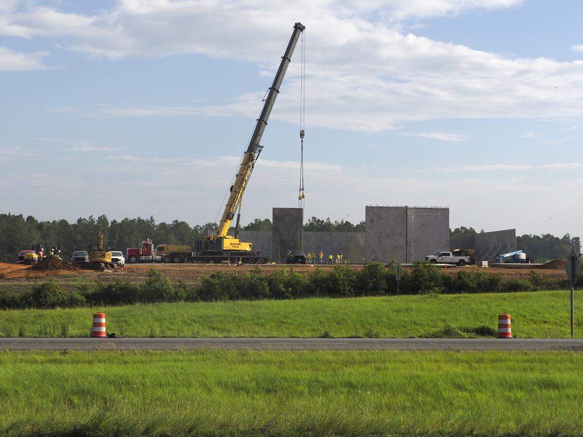 A crane lifts precast concrete panels into place at the site of the Buc-ee’s travel center that’s under construction along I-10 in South Mississippi.