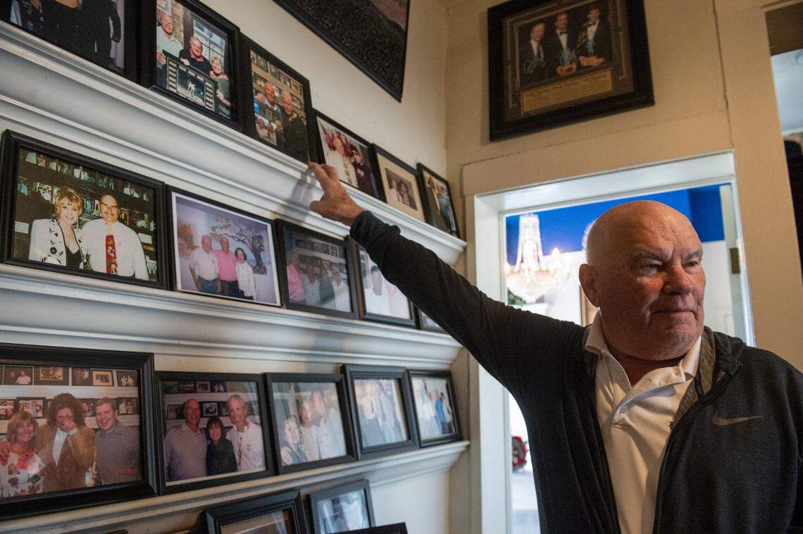 Mary Mahoney’s owner Bobby Mahoney points to photos of celebrities who have visited the Biloxi restaurant over the decades.
