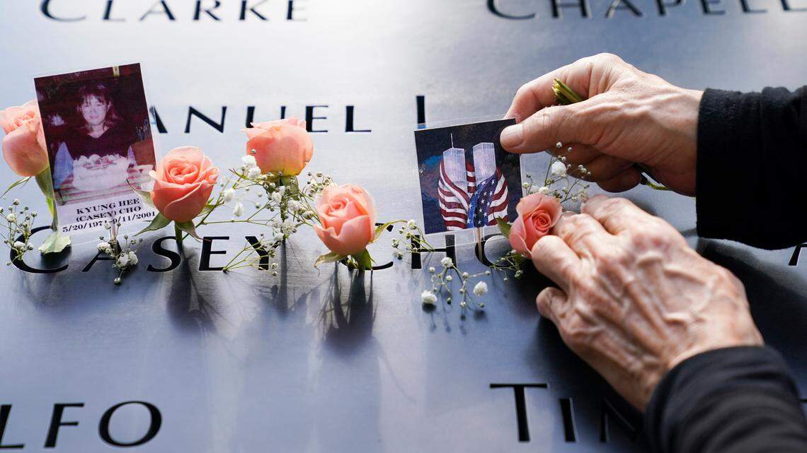 Mourners place flowers and pictures at the National September 11 Memorial and Museum, Friday, Sept. 11, 2020, in New York. A U.S. Army soldier is accused of plotting to attack the 9/11 Memorial, according to federal prosecutors. (AP Photo/John Minchillo)