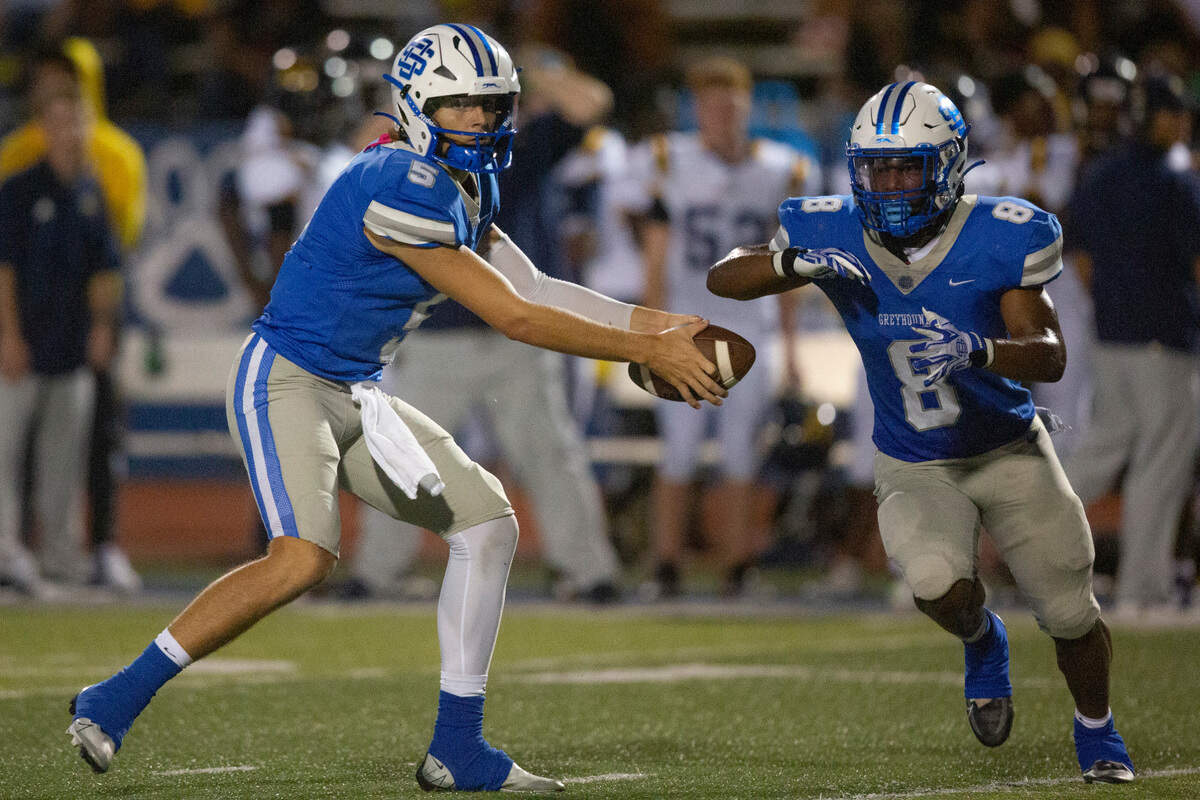 Ocean Springs’ Bray Hubbard, left, sets up a fake pass handoff with Ocean Springs’ Will Smith during a Jamboree game at Greyhound Stadium in Ocean Springs on Friday, Aug. 19, 2022.
