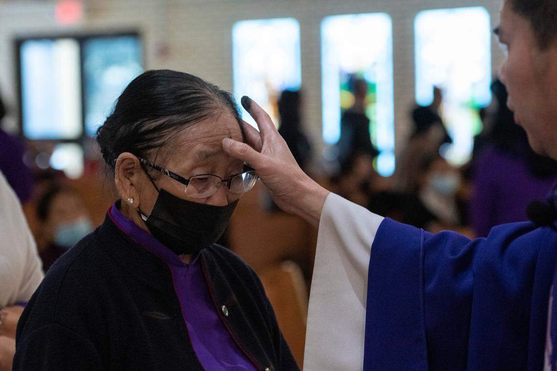 Father Thang John Pham marks black crosses on parishioners foreheads during an Ash Wednesday mass at the Vietnamese Martyrs Catholic Church in Biloxi on Wednesday, March 2, 2022.