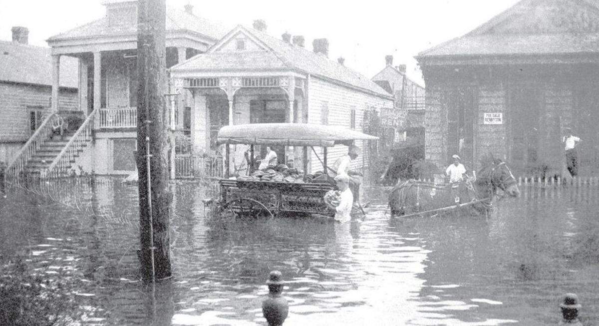 A man carries a load of bananas from a submerged wagon at Dupre and Baudin streets in Mid-City New Orleans in mid-April 1927.