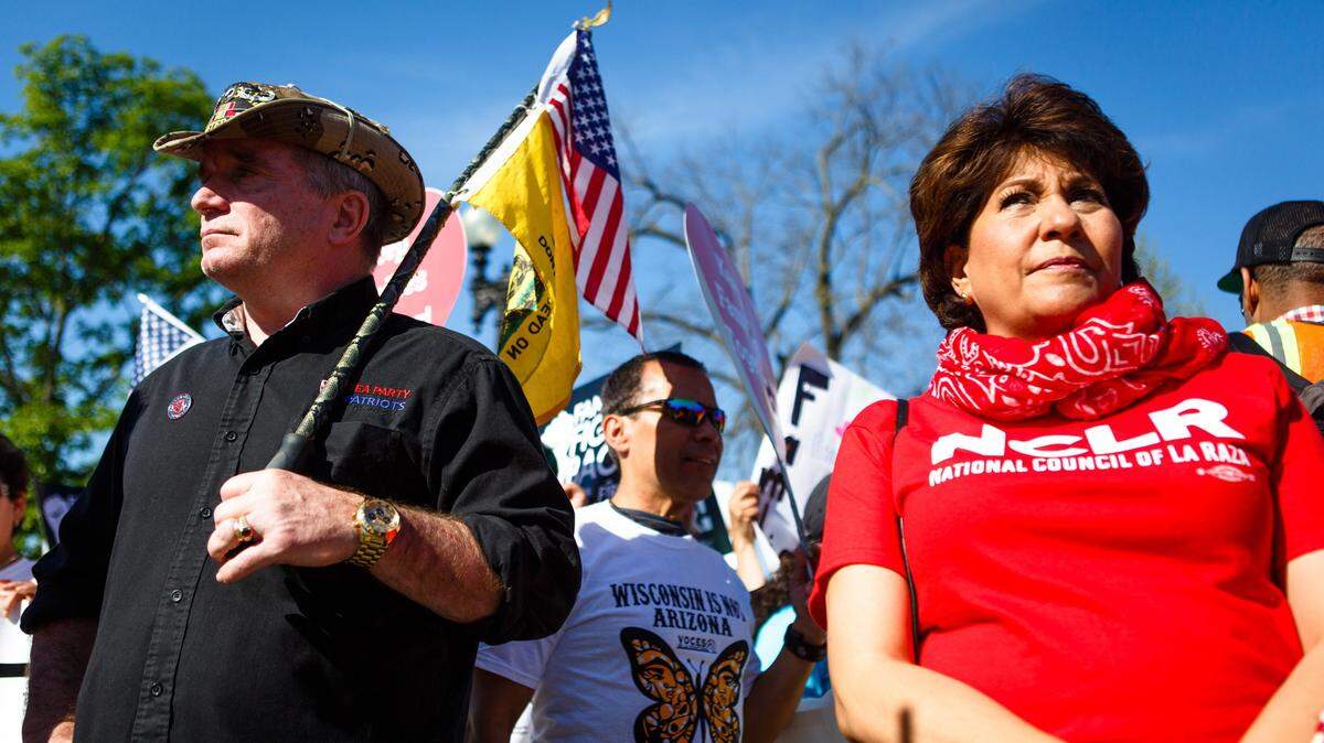 From left, Gregg Cummings, from Lamoni, Iowa and Janet Murgu'a, the head of the National Council of La Raza, stand next to each other Monday morning, April 18, 2016 outside the U.S. Supreme Court in Washington, D.C. Cummings is a Tea Party supporter and Murgu'a in favor of immigration rights. (Keith Lane/McClatchy/TNS)