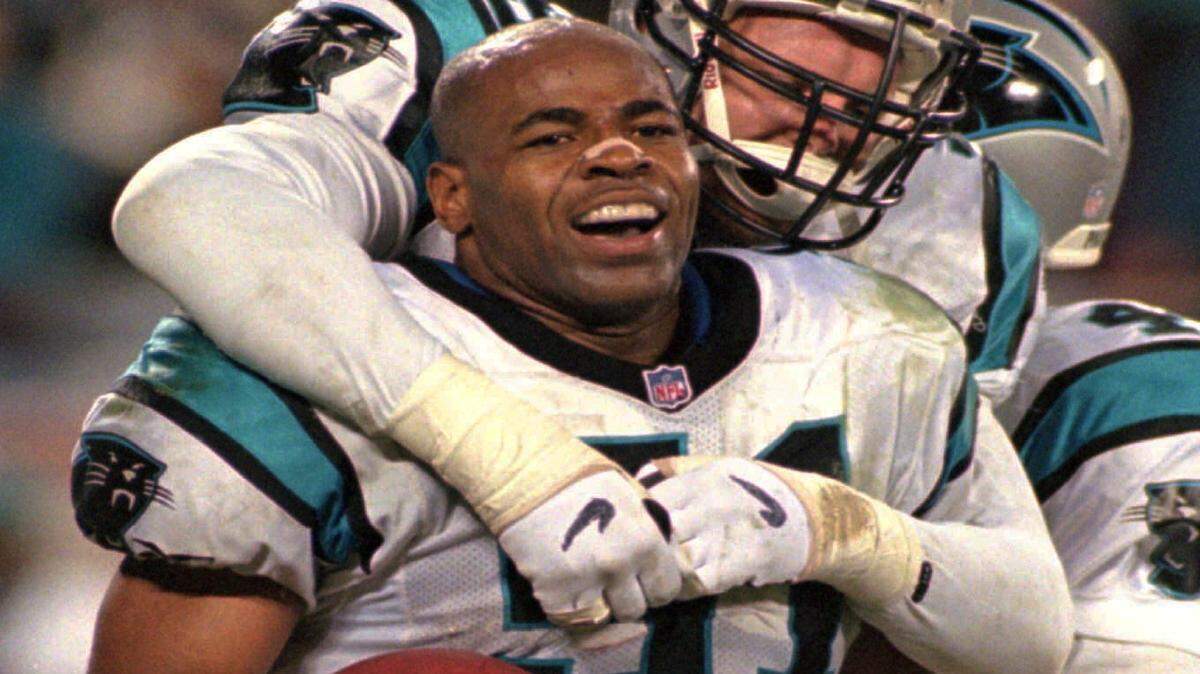 Carolina Panthers linebacker Sam Mills, front, celebrates with teammate Matt Elliott after his interception in the final moments of the Panthers' 26-17 win over the Dallas Cowboys at Ericsson Stadium in Charlotte, N.C., Sunday Jan. 5, 1997.(AP Photo/Chuck Burton)