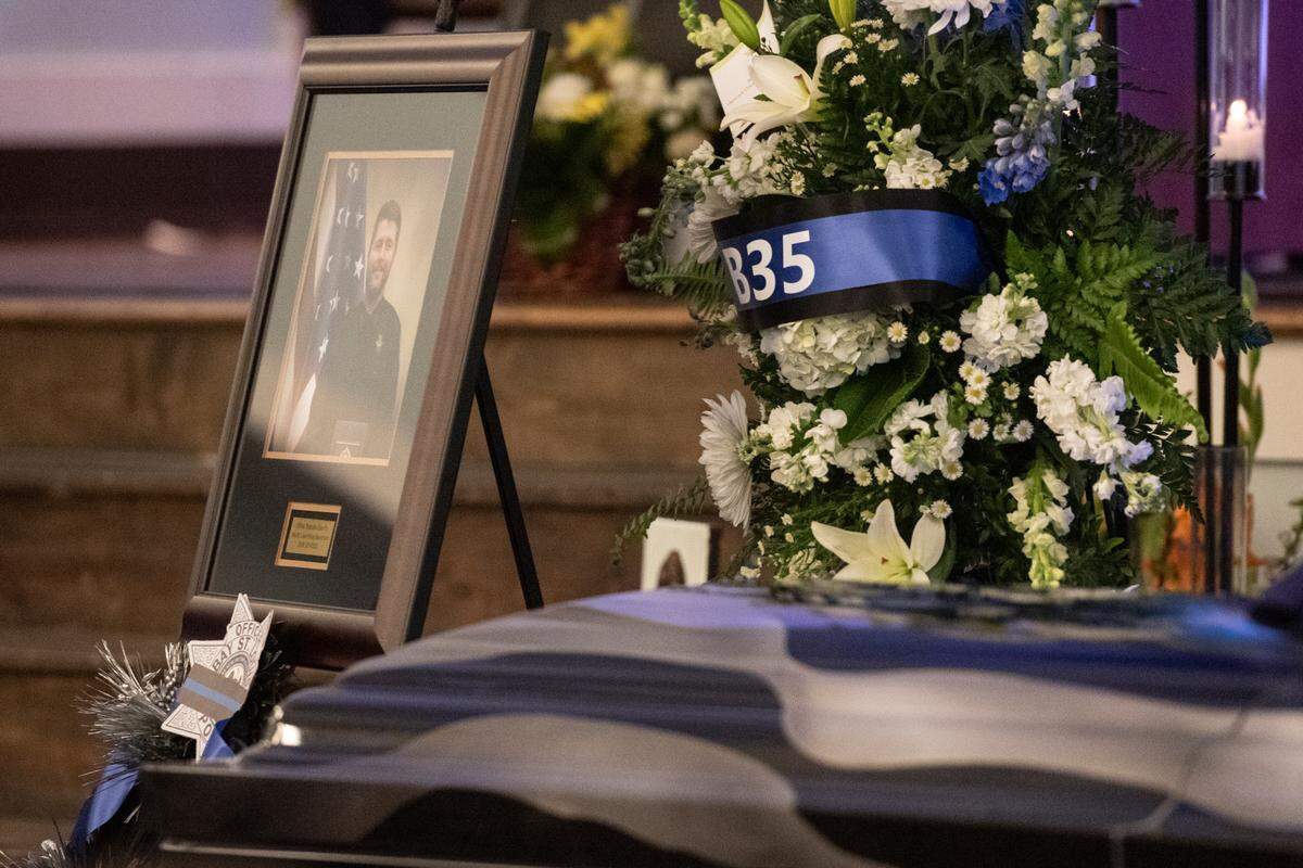 Branden Estorffe’s portrait looks out on the crowd during the funeral of Bay St. Louis police officers Sgt. Steven Robin and Branden Estorffe at the Bay St. Louis Community Center in Bay St. Louis on Wednesday, Dec. 21, 2022. Robin and Estorffe were killed responding to a call at a Motel 6 on Dec. 14.