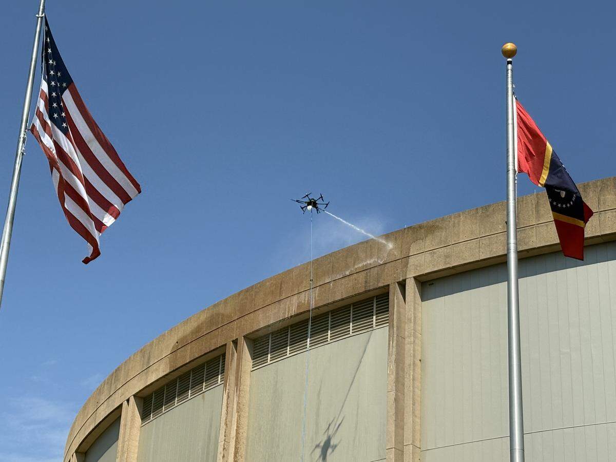 Large drones are spraying down the huge, circular sides of the Coast Coliseum Thursday, Aug. 28 at the beach in Biloxi. Mississippi company FlyBy Shine is doing the work.